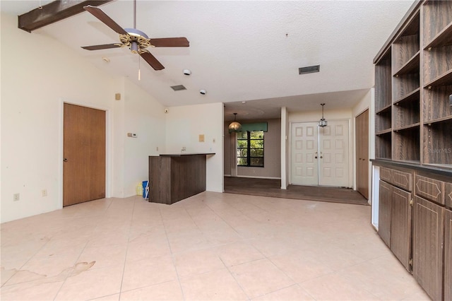 unfurnished living room featuring a ceiling fan, visible vents, and lofted ceiling with beams