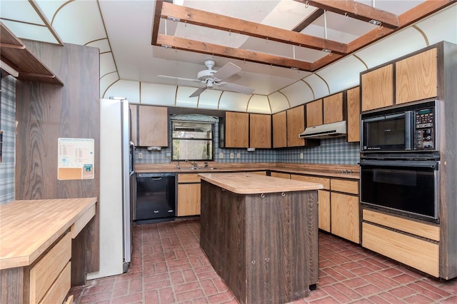 kitchen featuring tasteful backsplash, a sink, wood counters, under cabinet range hood, and black appliances