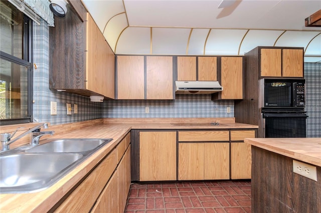 kitchen with decorative backsplash, under cabinet range hood, black appliances, wooden counters, and a sink