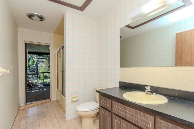 full bathroom featuring toilet, bath / shower combo with glass door, visible vents, vanity, and wallpapered walls