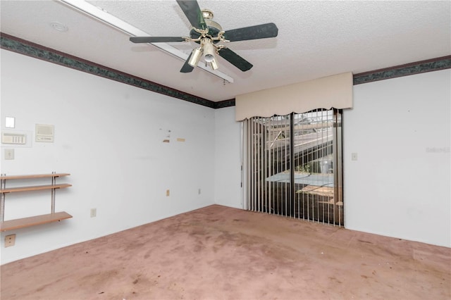 spare room with a textured ceiling, carpet, and a ceiling fan