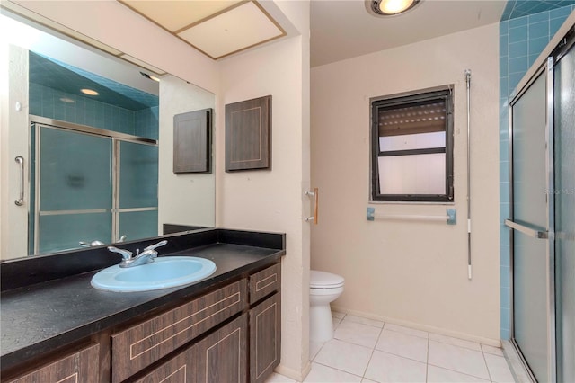 bathroom with a stall shower, tile patterned flooring, vanity, and toilet