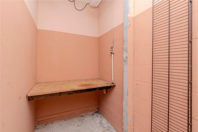 interior space with concrete block wall and unfinished concrete flooring