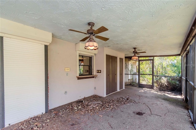 unfurnished sunroom with ceiling fan