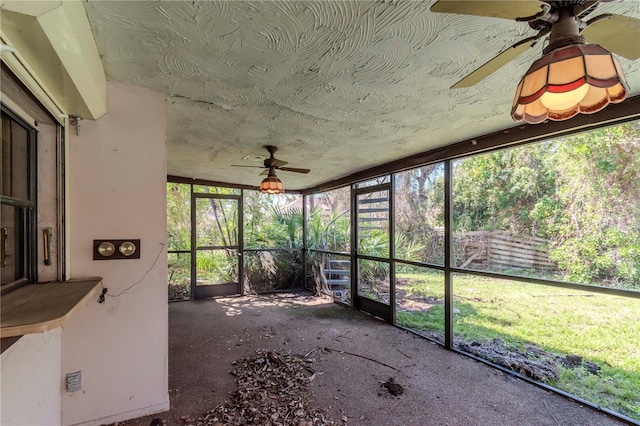 unfurnished sunroom featuring ceiling fan