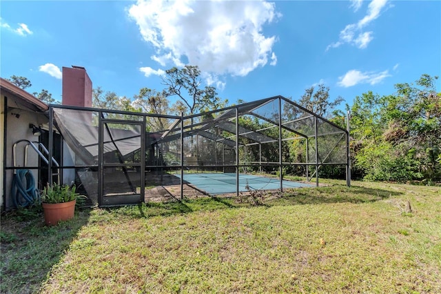 back of house with a lanai, a chimney, and a lawn