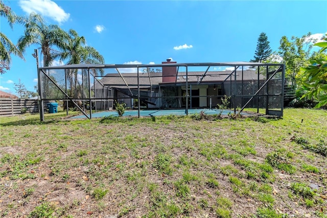 back of house with glass enclosure and fence