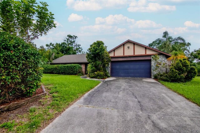 5101 Estates Cir, Sarasota, FL 34243 - view of front facade with driveway, a front yard, stone siding, and an attached garage