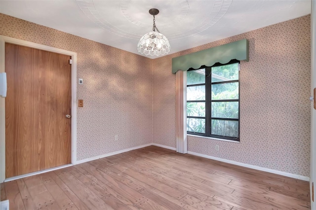 5101 Estates Cir, Sarasota, FL 34243 - spare room with a chandelier, light wood-type flooring, and wallpapered walls