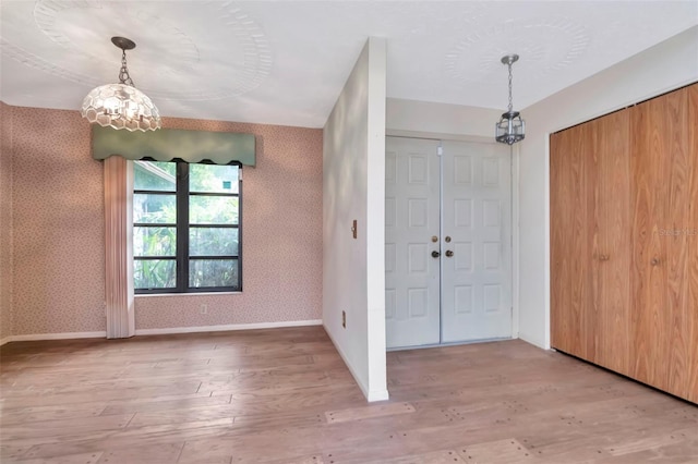 5101 Estates Cir, Sarasota, FL 34243 - foyer with a chandelier, light wood finished floors, and wallpapered walls