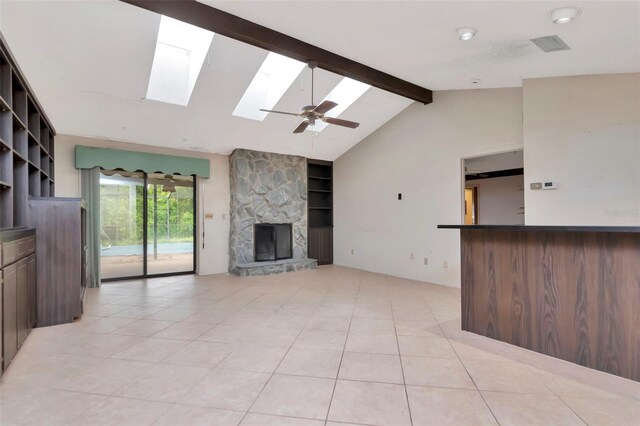 5101 Estates Cir, Sarasota, FL 34243 - unfurnished living room featuring a skylight, light tile patterned floors, a fireplace, a ceiling fan, and built in shelves