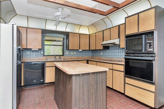 5101 Estates Cir, Sarasota, FL 34243 - kitchen with black appliances, under cabinet range hood, butcher block counters, brick patterned floors, and decorative backsplash