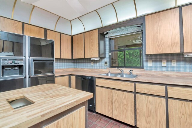 5101 Estates Cir, Sarasota, FL 34243 - kitchen featuring dishwashing machine, wood counters, tasteful backsplash, brick patterned flooring, and light brown cabinetry