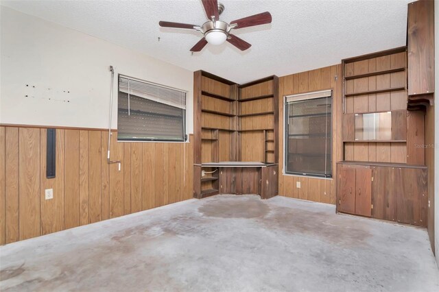 5101 Estates Cir, Sarasota, FL 34243 - unfurnished living room featuring a ceiling fan, wooden walls, a textured ceiling, and a wainscoted wall
