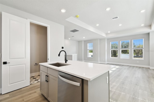4717 W Mccoy St Unit 9, Tampa, FL 33616 - kitchen featuring stainless steel dishwasher, a sink, open floor plan, baseboards, and an island with sink