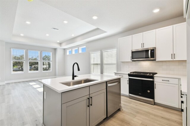 4717 W Mccoy St Unit 9, Tampa, FL 33616 - kitchen featuring appliances with stainless steel finishes, a sink, a raised ceiling, light countertops, and tasteful backsplash