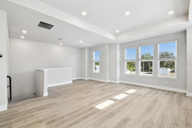 4717 W Mccoy St Unit 9, Tampa, FL 33616 - unfurnished living room with light wood-type flooring, recessed lighting, baseboards, and a tray ceiling