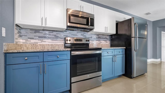 kitchen featuring white cabinets, blue cabinets, light stone countertops, stainless steel appliances, and backsplash