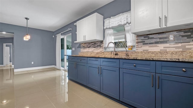 kitchen featuring backsplash, white cabinets, light stone countertops, blue cabinets, and baseboards