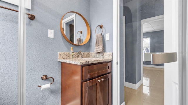 bathroom with tile patterned flooring, vanity, and baseboards