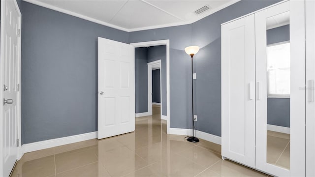 unfurnished bedroom featuring a closet, tile patterned flooring, visible vents, and baseboards