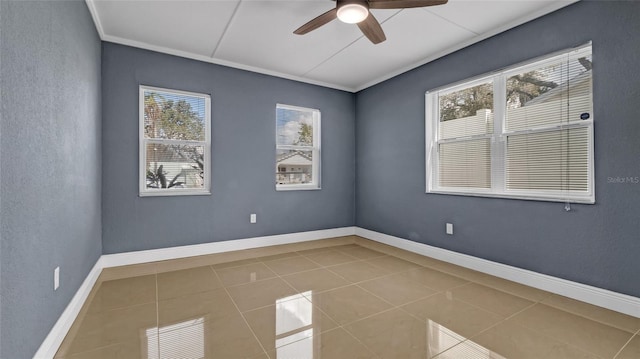 empty room with a ceiling fan, tile patterned flooring, crown molding, and baseboards