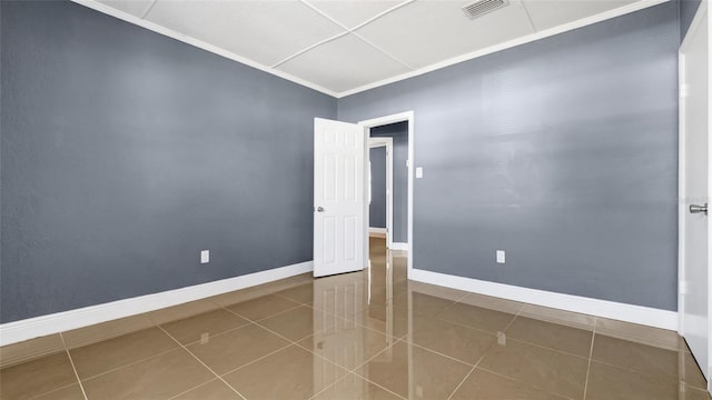 unfurnished room with crown molding, tile patterned flooring, visible vents, and baseboards