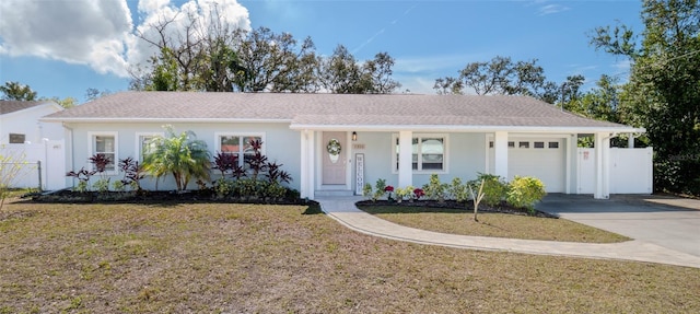 ranch-style home with a garage, driveway, a front lawn, and fence