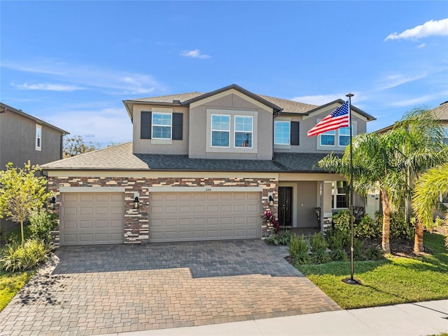 view of front of home featuring a garage, a shingled roof, decorative driveway, and stucco siding