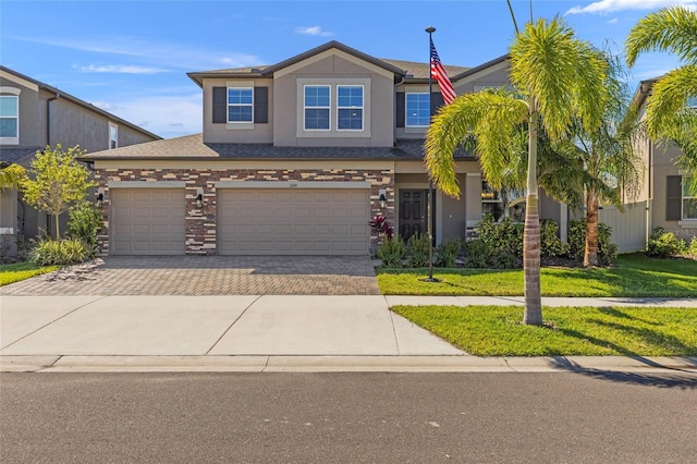 view of front of home featuring a front lawn, decorative driveway, and stucco siding