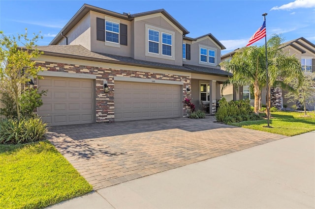 view of front facade featuring stone siding, decorative driveway, an attached garage, and stucco siding