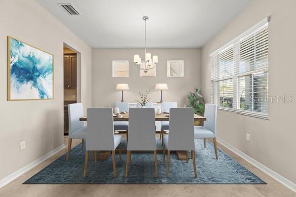 dining room with baseboards, visible vents, and an inviting chandelier