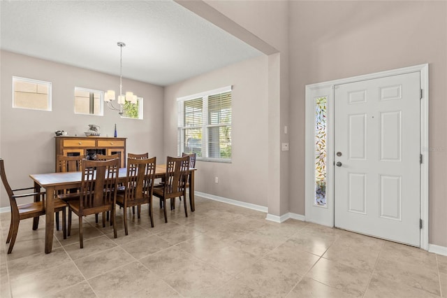 entryway with light tile patterned floors, baseboards, and an inviting chandelier