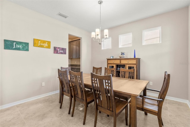 dining area with light tile patterned floors, an inviting chandelier, visible vents, and baseboards