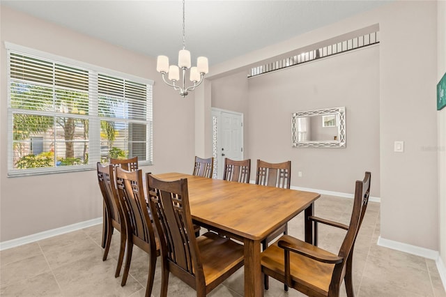 dining area featuring a chandelier, light tile patterned floors, and baseboards