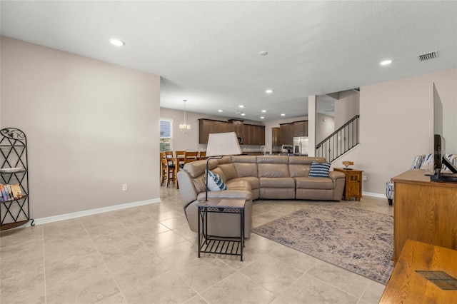 living area featuring light tile patterned floors, a textured ceiling, recessed lighting, visible vents, and baseboards