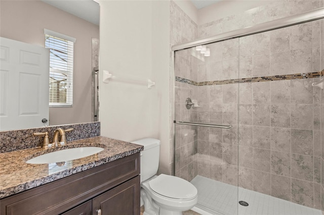 bathroom featuring a stall shower, vanity, and toilet