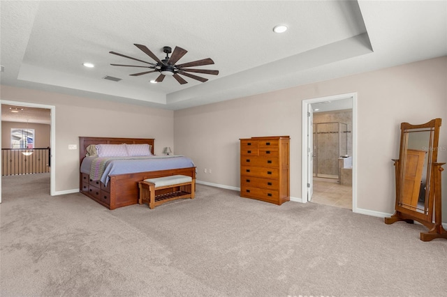 bedroom with carpet floors, a raised ceiling, visible vents, and baseboards