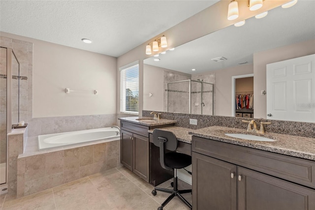 full bathroom with a stall shower, visible vents, a garden tub, a spacious closet, and vanity