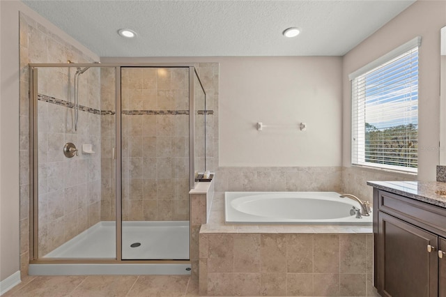 bathroom featuring tile patterned floors, a shower stall, a bath, and vanity