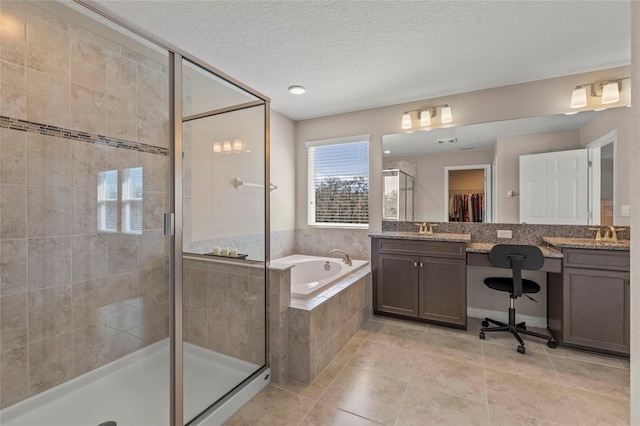 full bath featuring a textured ceiling, a bath, tile patterned floors, a stall shower, and a walk in closet