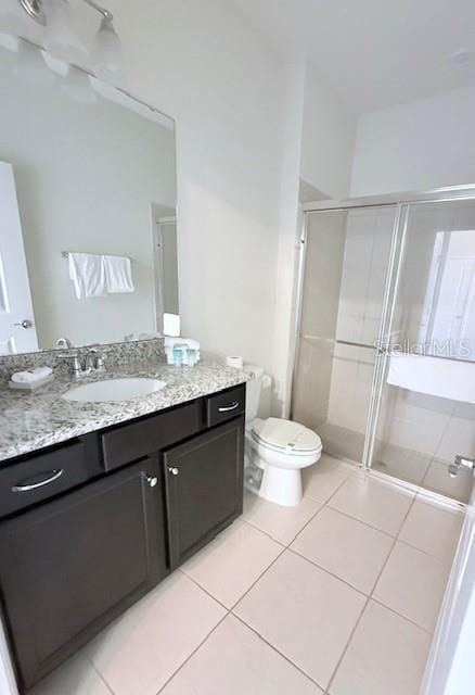 bathroom featuring a stall shower, tile patterned flooring, vanity, and toilet