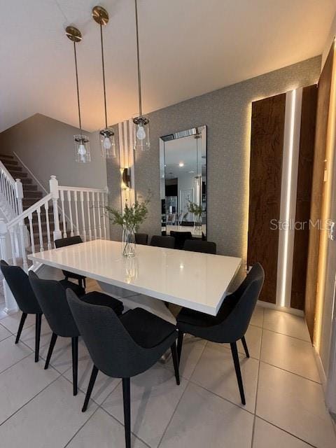 dining room featuring light tile patterned floors and stairs