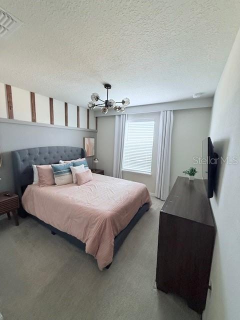 carpeted bedroom with visible vents, a textured ceiling, and an inviting chandelier