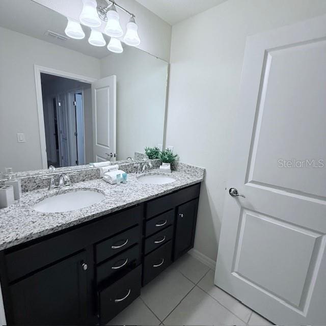 bathroom with double vanity, an inviting chandelier, visible vents, and a sink