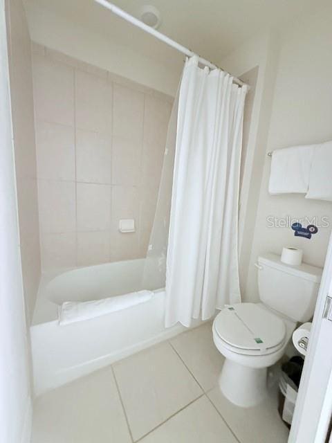 bathroom featuring toilet, tile patterned flooring, and shower / tub combo with curtain