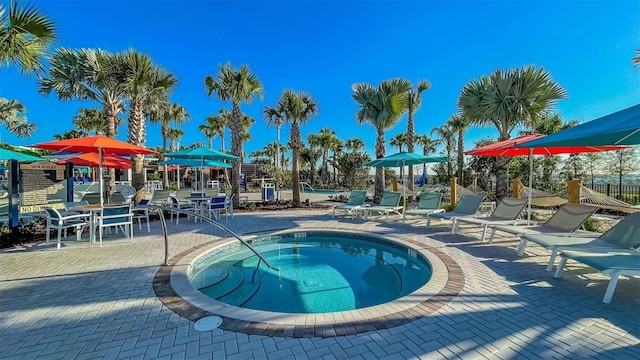 view of swimming pool featuring a patio area, fence, and a hot tub