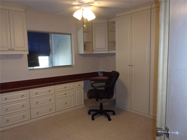 carpeted office featuring a ceiling fan and built in study area