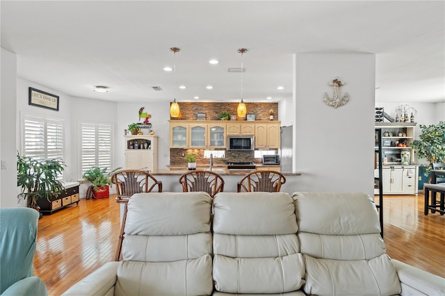 living room with recessed lighting, visible vents, and light wood-style flooring