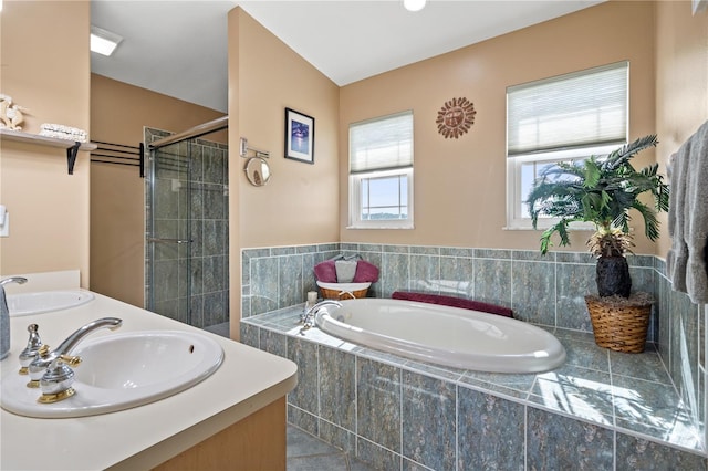 bathroom with double vanity, a stall shower, a sink, and a bath